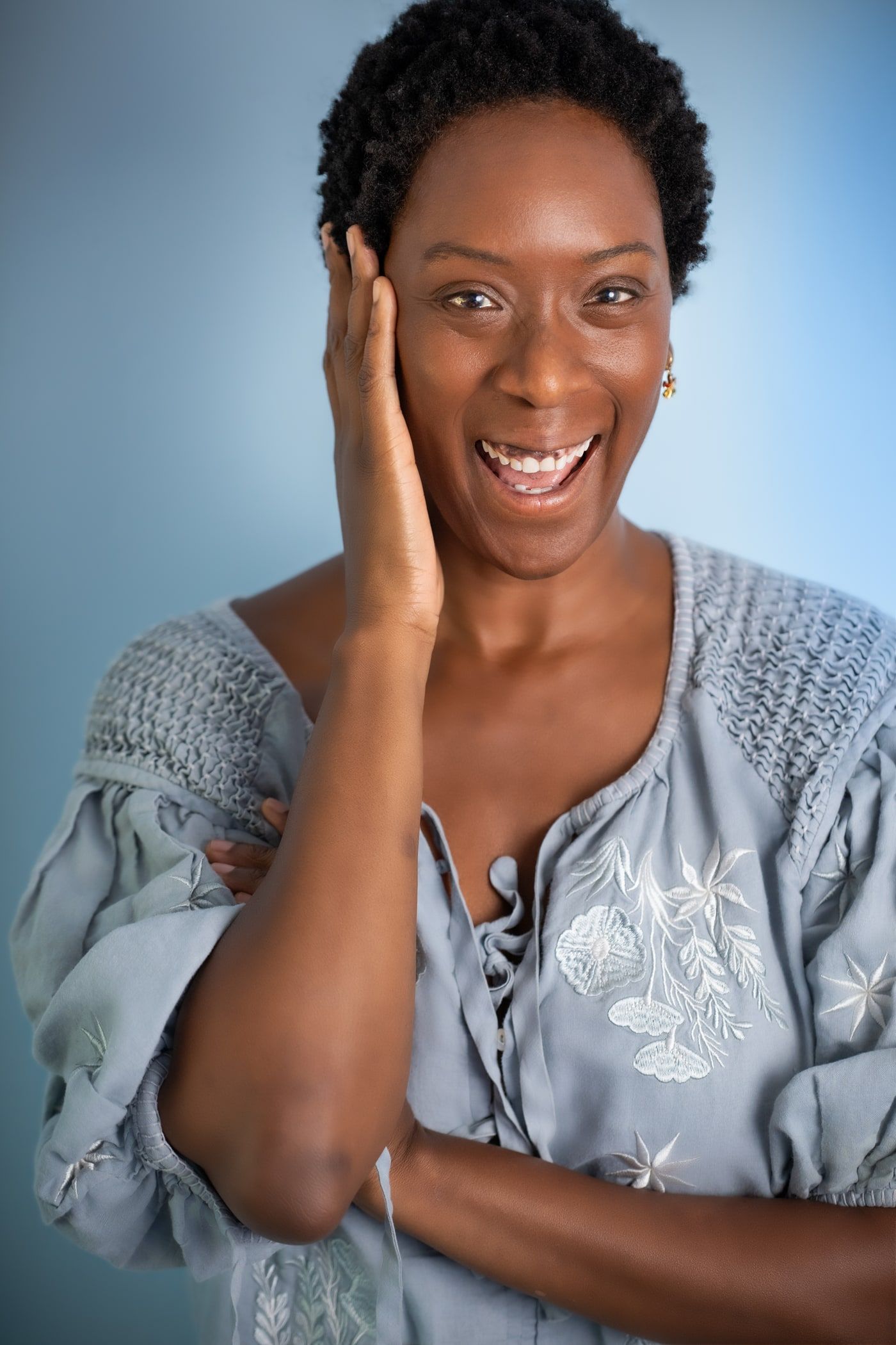Yolessa laughing with a hand to her cheek